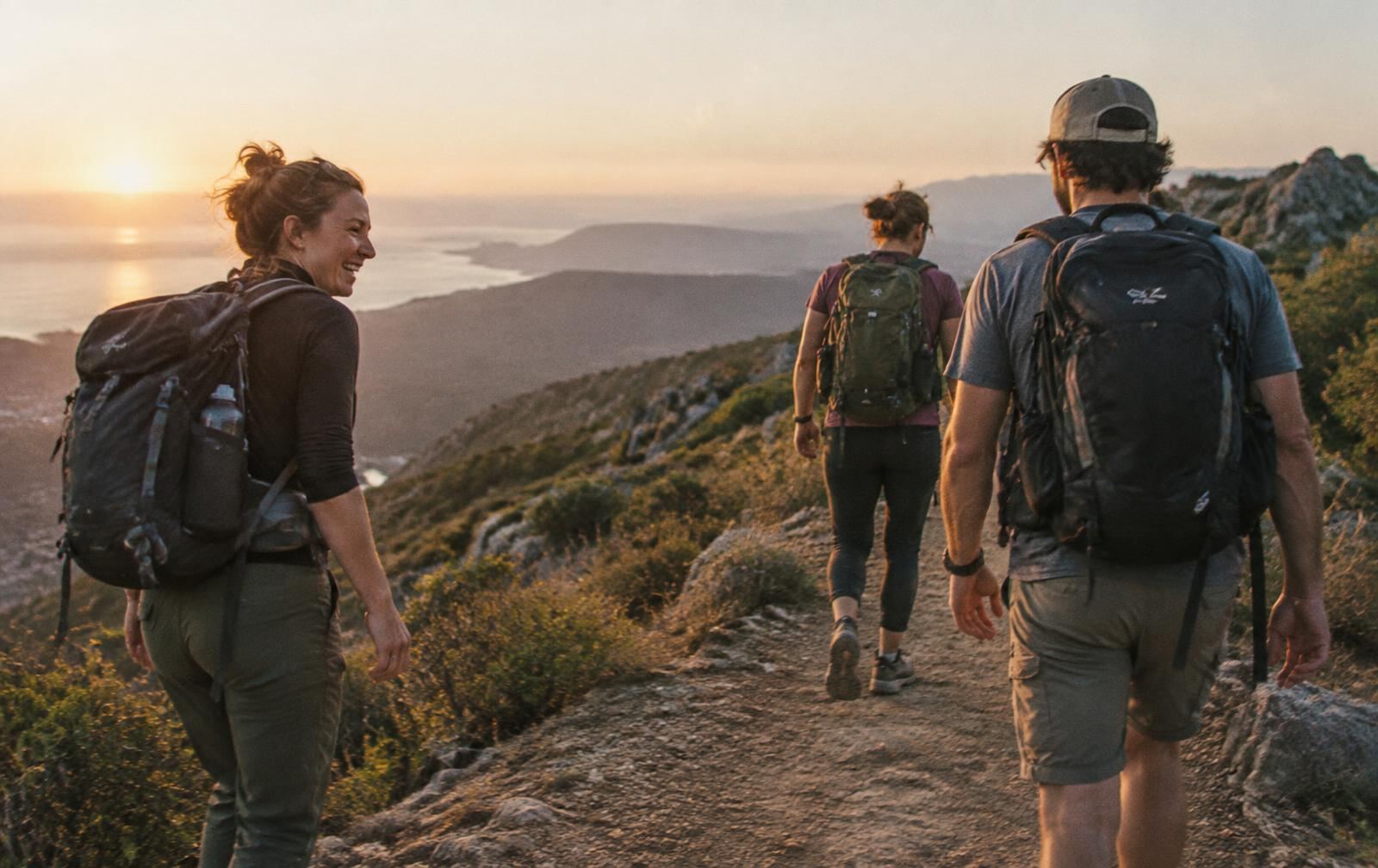 Friends hiking a ridge trail at golden hour